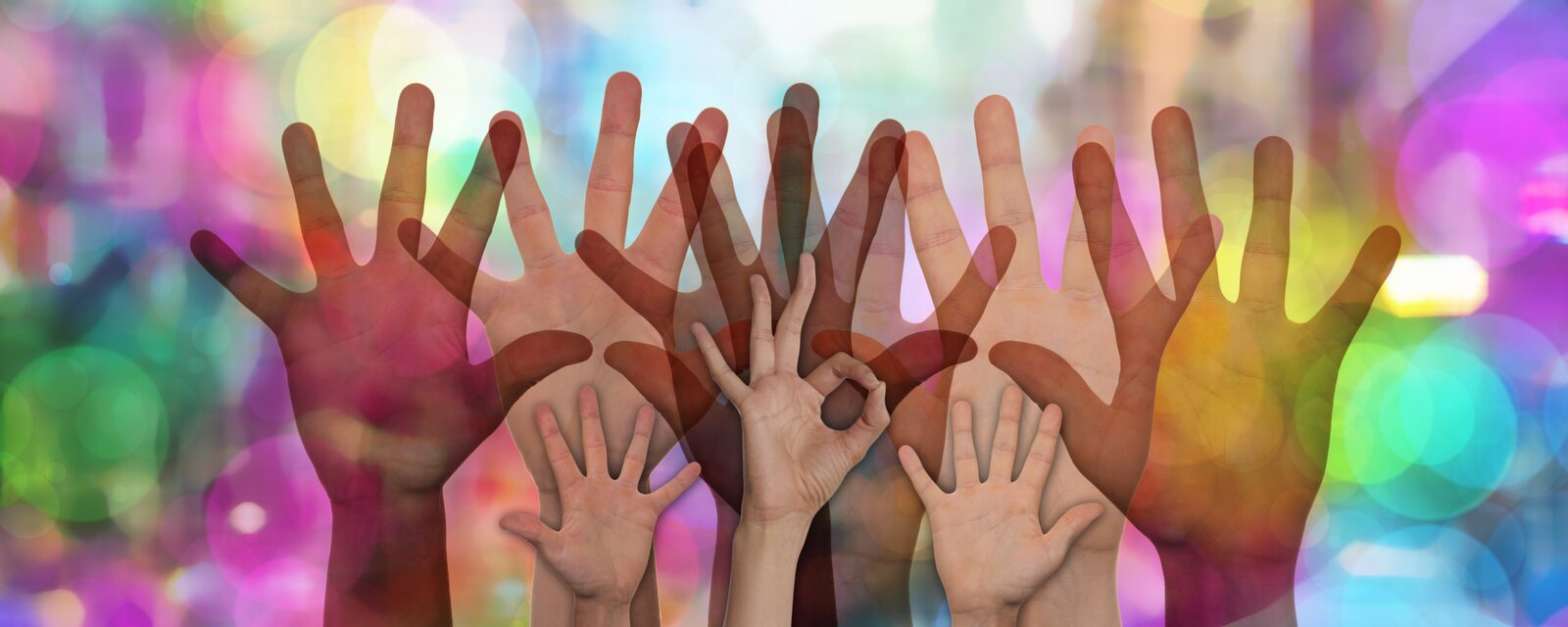 Erhobene Hände vor farbigem Hintergrund - Symbolbild für freiwillige Helfer_innen