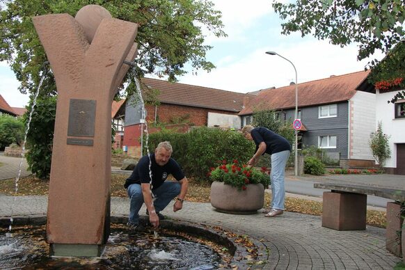 Wilfried Rösser kümmert sich um die Reinigung eines gespendeten Brunnens von Gästen aus Japan in Lahntal-Sterzhausen.